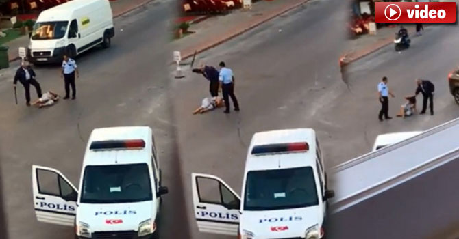 Polisler yerdeki kadına copla vurup, tekmeledi