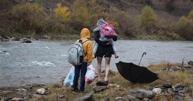 Babalarının sırtında okula gidiyorlar!