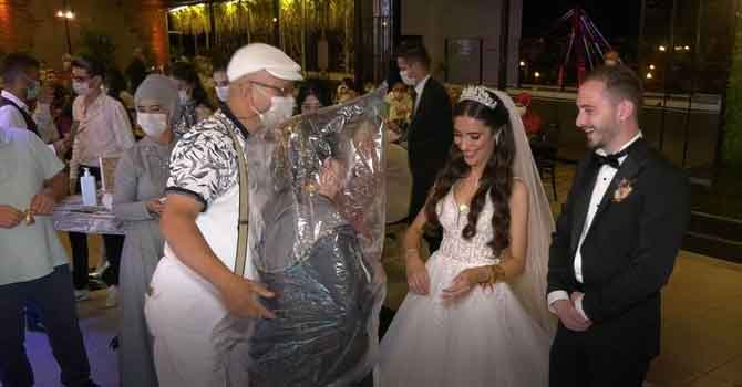 Kafasına poşet geçirip gelin ve damada sarıldı