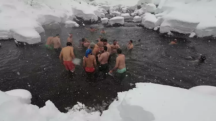 Kar yağışına rağmen derede yüzdüler